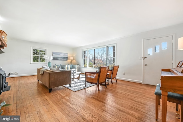 living area featuring light wood-style floors and baseboards