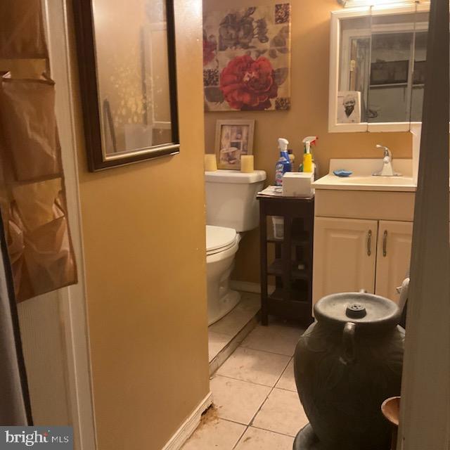 bathroom featuring tile patterned flooring, toilet, vanity, and baseboards