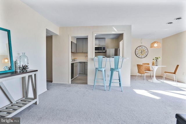 kitchen with visible vents, baseboards, carpet floors, gray cabinets, and appliances with stainless steel finishes