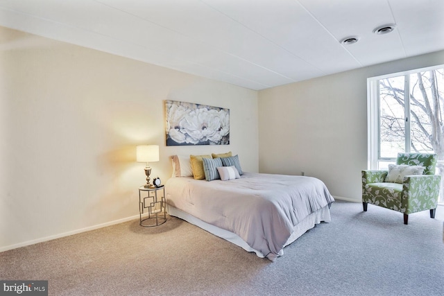 bedroom featuring visible vents, baseboards, and carpet