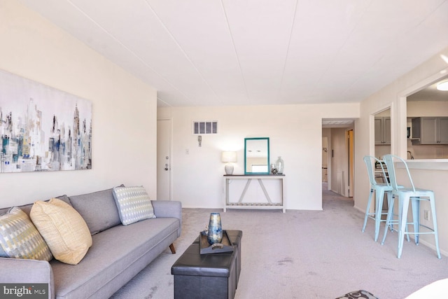 living area with visible vents and carpet