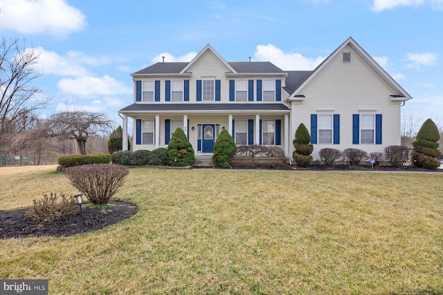 colonial home featuring a front yard and a porch