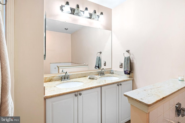 full bathroom with double vanity and a sink