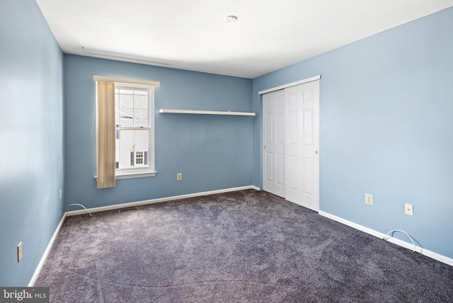 unfurnished bedroom featuring a closet, baseboards, and carpet floors