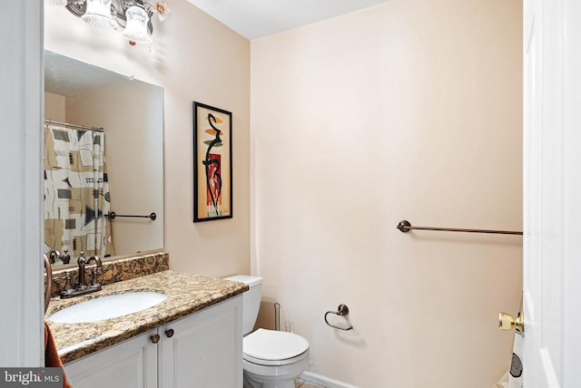 full bathroom with vanity, toilet, and baseboards