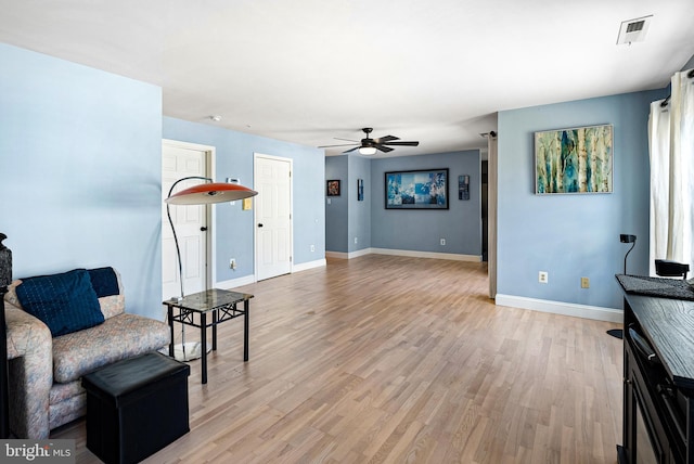 sitting room with visible vents, baseboards, light wood-type flooring, and ceiling fan