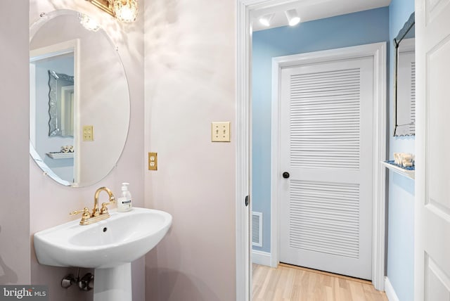 bathroom with a sink, visible vents, and wood finished floors