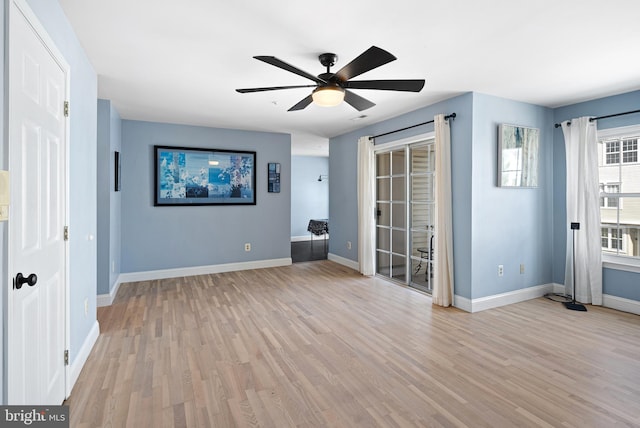 interior space with baseboards, light wood-style flooring, and a ceiling fan