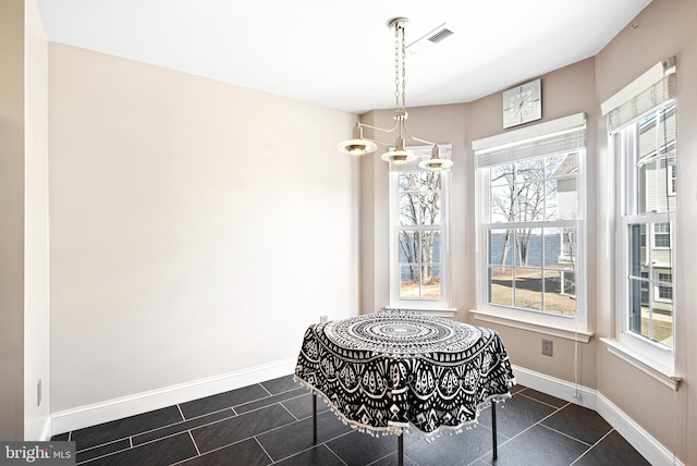 dining space with dark tile patterned flooring, baseboards, and visible vents