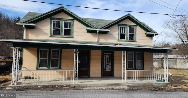 view of front of home featuring roof with shingles and covered porch