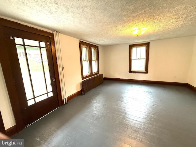 15941 Foundry Row NW, Mount Savage, MD 21545 - empty room featuring radiator, healthy amount of natural light, a textured ceiling, and wood finished floors