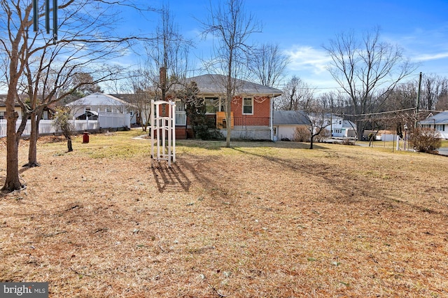 exterior space with brick siding, a front lawn, and fence