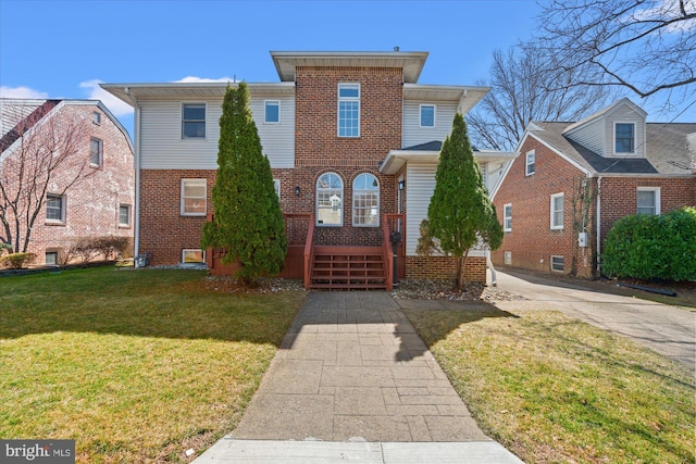 view of front of home featuring brick siding and a front yard