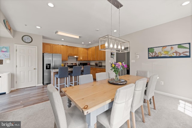 dining space with recessed lighting, baseboards, a chandelier, and light carpet