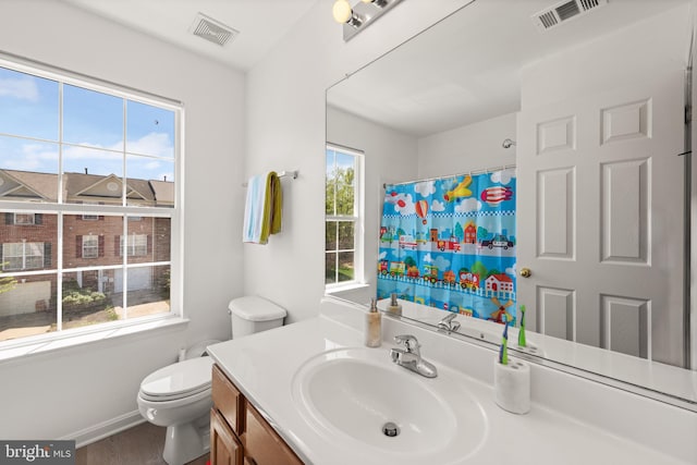 full bath featuring visible vents, curtained shower, toilet, and vanity