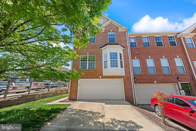 view of property featuring an attached garage, driveway, and brick siding