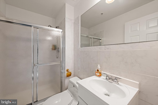 full bathroom with toilet, tile walls, a shower stall, and vanity