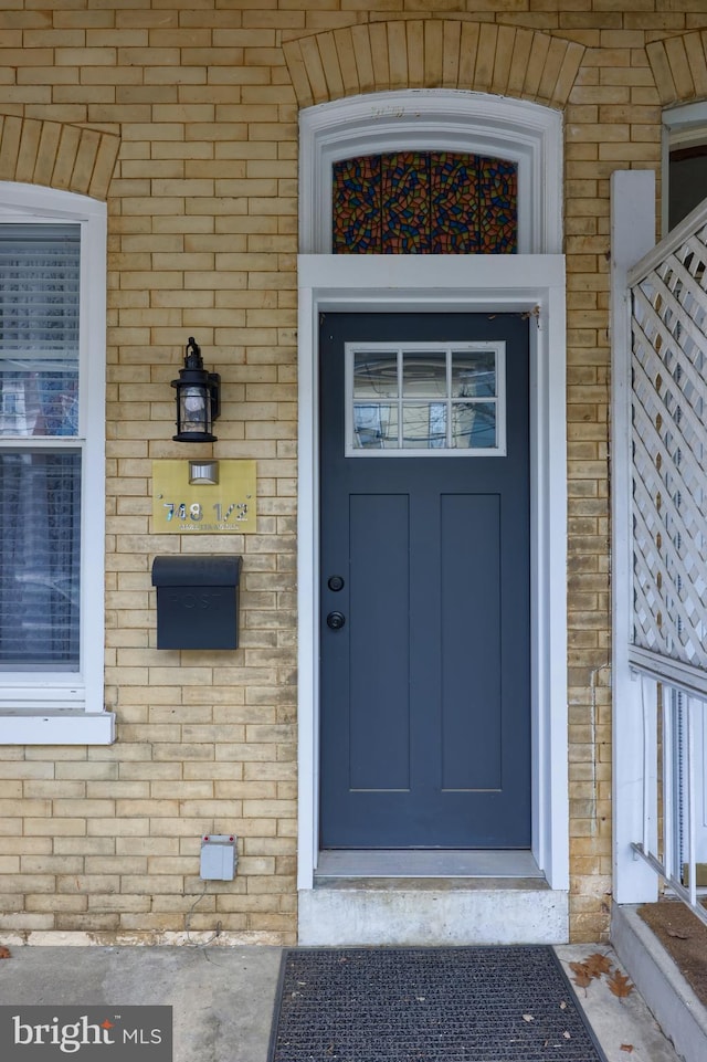 entrance to property featuring brick siding