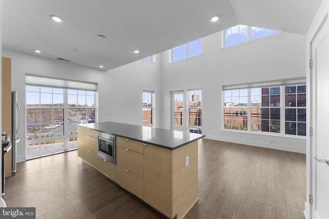 kitchen with visible vents, a center island, dark wood-style floors, stainless steel appliances, and modern cabinets