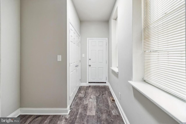 doorway to outside featuring visible vents, wood finished floors, and baseboards