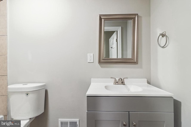 bathroom featuring vanity, toilet, and visible vents