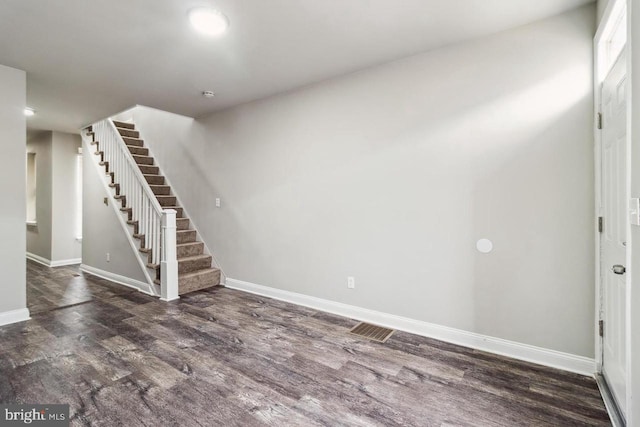 interior space featuring stairs, baseboards, and wood finished floors