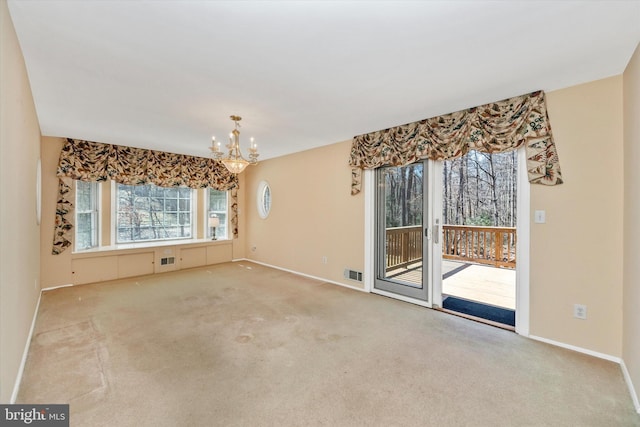 empty room featuring an inviting chandelier, carpet, visible vents, and baseboards