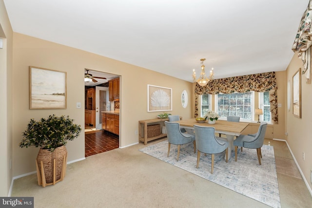 carpeted dining space featuring baseboards and an inviting chandelier