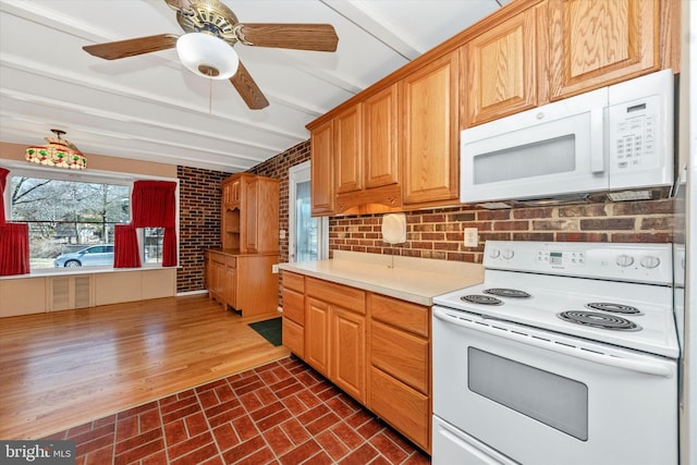 kitchen featuring white appliances, a ceiling fan, brick wall, brick floor, and light countertops