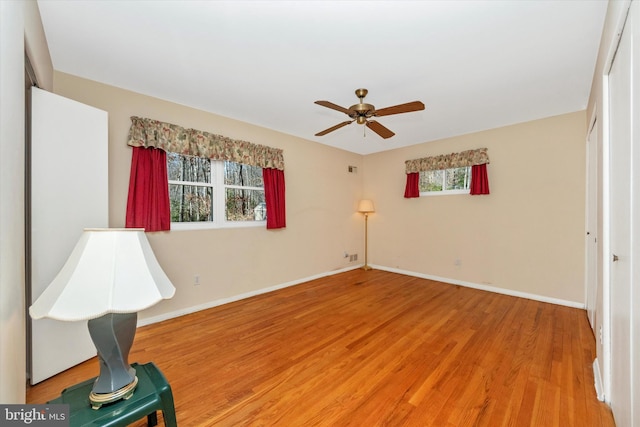 unfurnished bedroom featuring multiple windows, baseboards, and light wood finished floors