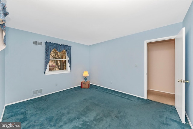 spare room featuring baseboards, visible vents, and carpet floors