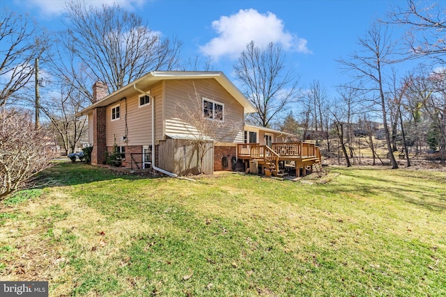 rear view of property featuring a wooden deck, a yard, a chimney, stairs, and brick siding