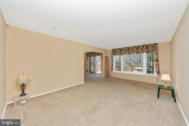 unfurnished living room featuring baseboards and carpet