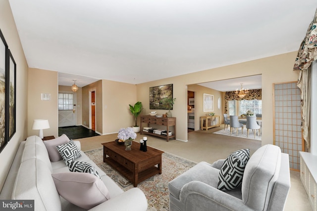 living area featuring carpet flooring and an inviting chandelier