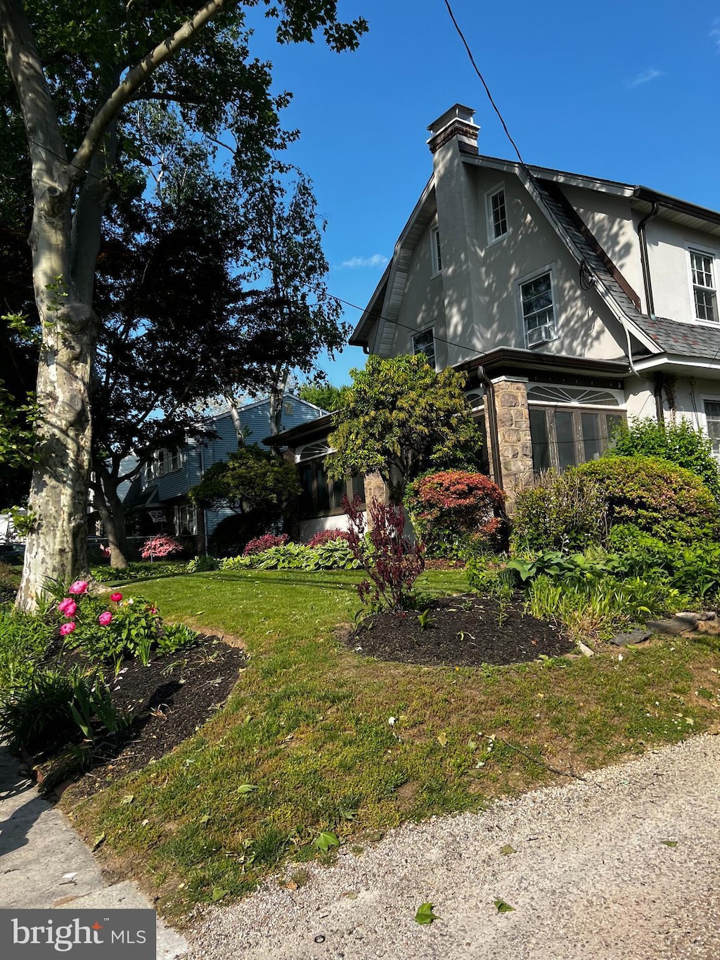 view of side of property with a lawn, a chimney, and stucco siding