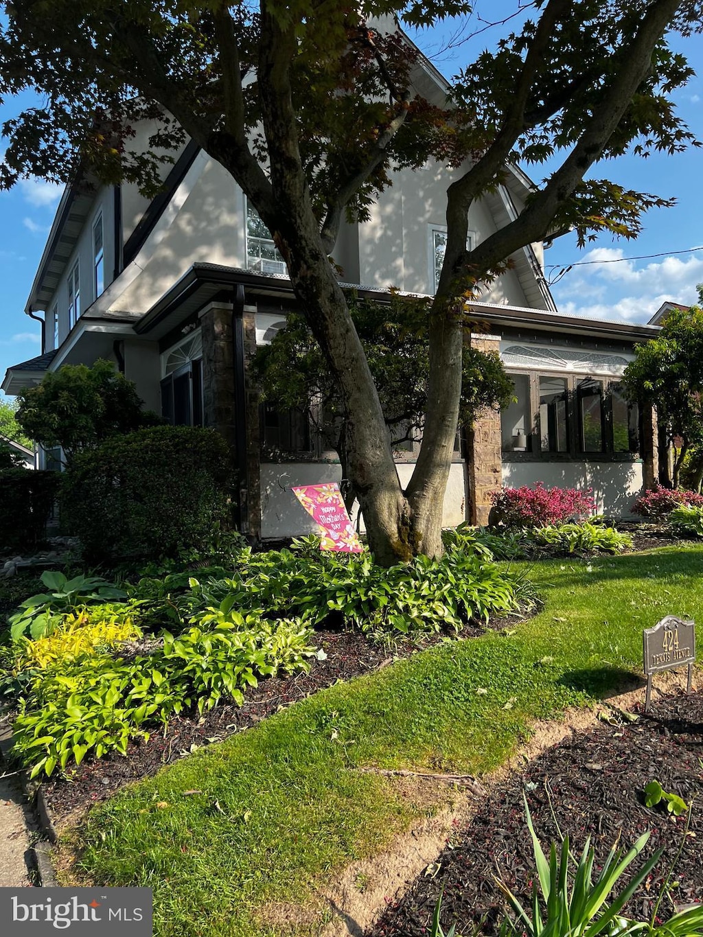 view of side of home with stone siding and a lawn