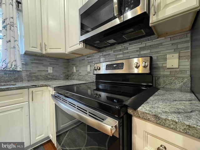 kitchen with white cabinetry, light stone counters, tasteful backsplash, and stainless steel appliances