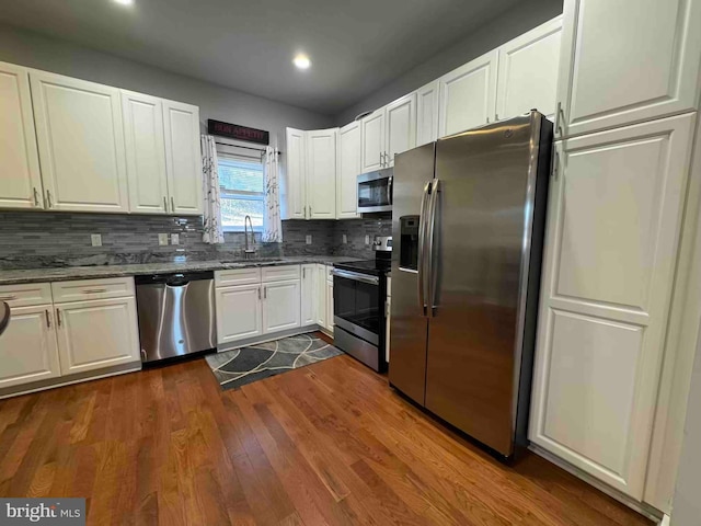 kitchen featuring dark wood-style flooring, white cabinets, appliances with stainless steel finishes, and a sink