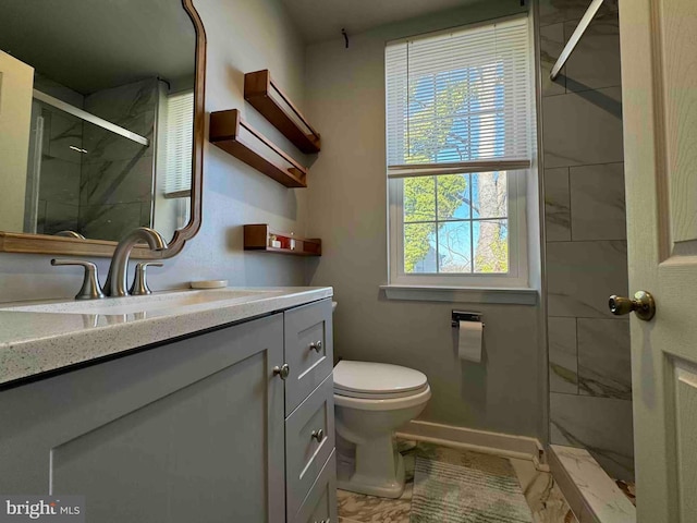 full bath featuring baseboards, vanity, a shower stall, and toilet