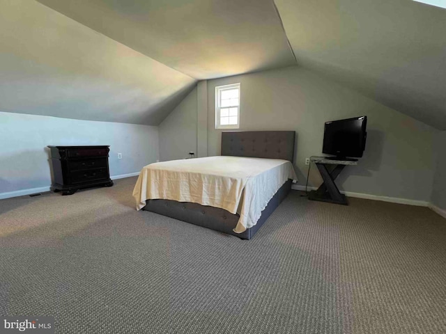 carpeted bedroom featuring lofted ceiling and baseboards