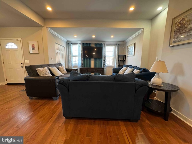 living room featuring recessed lighting, baseboards, wood finished floors, and crown molding