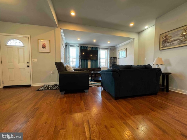 living area featuring ornamental molding, baseboards, and hardwood / wood-style floors