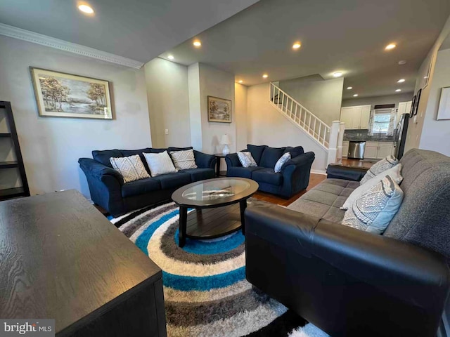 living room with recessed lighting, wood finished floors, stairs, and ornamental molding