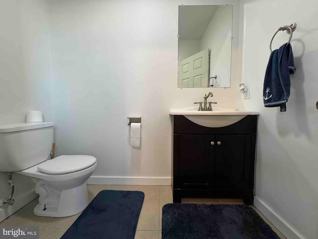 bathroom with baseboards, toilet, vanity, and tile patterned flooring