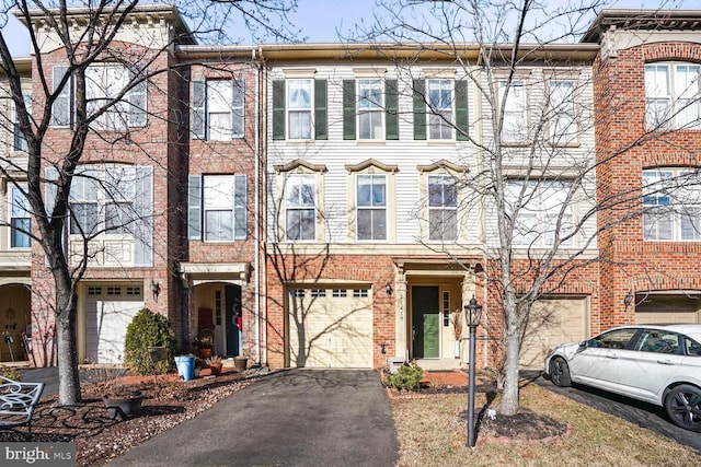 multi unit property featuring driveway, brick siding, and an attached garage