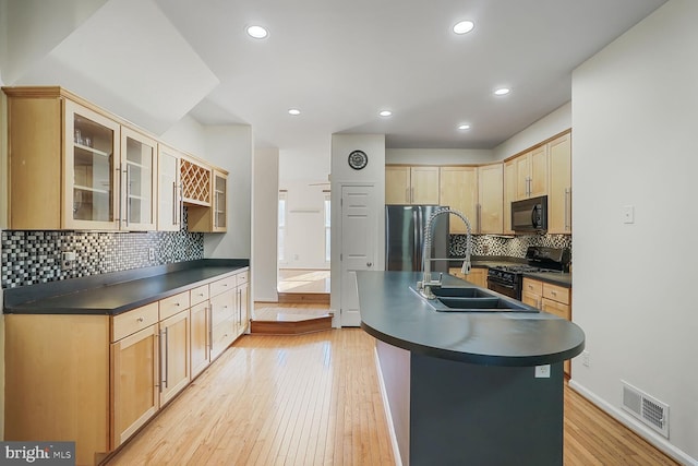 kitchen featuring visible vents, dark countertops, freestanding refrigerator, black microwave, and gas range