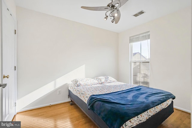 bedroom with visible vents, baseboards, ceiling fan, and wood-type flooring