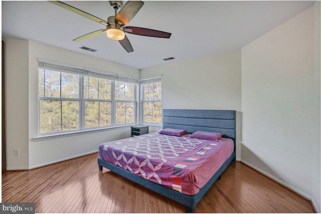 bedroom featuring baseboards, visible vents, and wood-type flooring