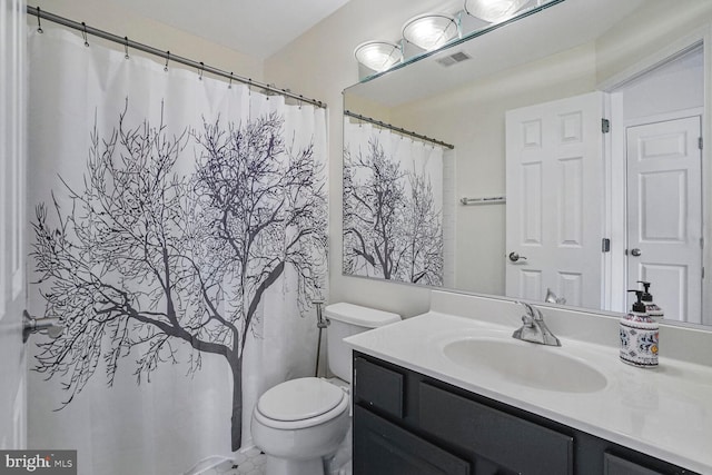 bathroom featuring visible vents, toilet, and vanity