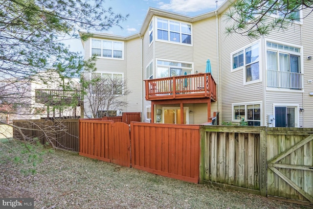 rear view of house with a fenced backyard and a gate